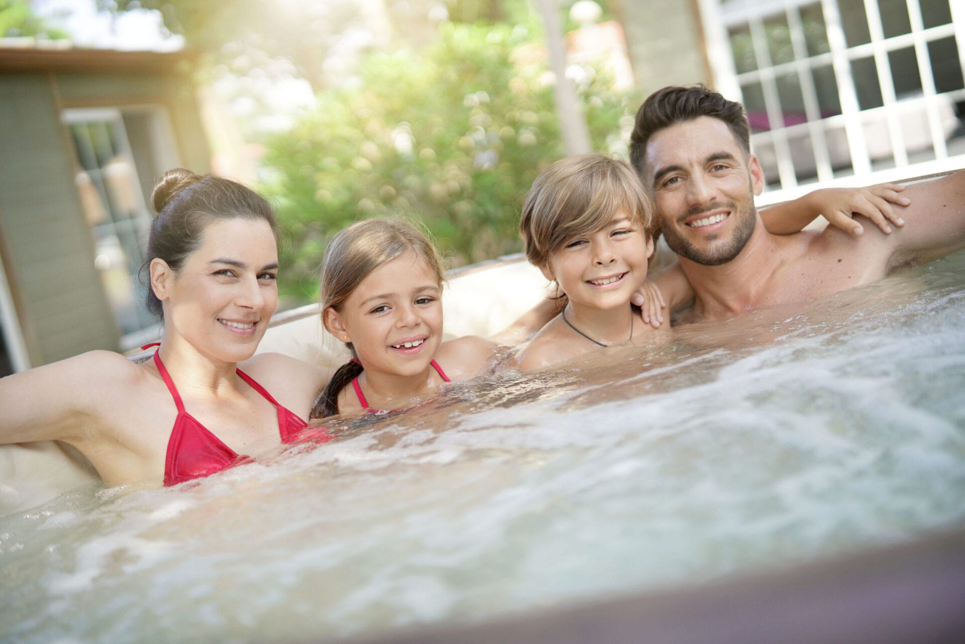 Family of 4 enjoying bath in jacuzzi tilers at industrial floor tiling renovation